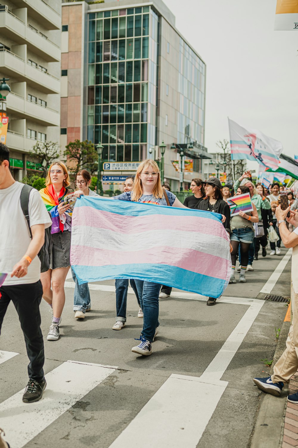 un groupe de personnes marchant dans une rue tenant un drapeau