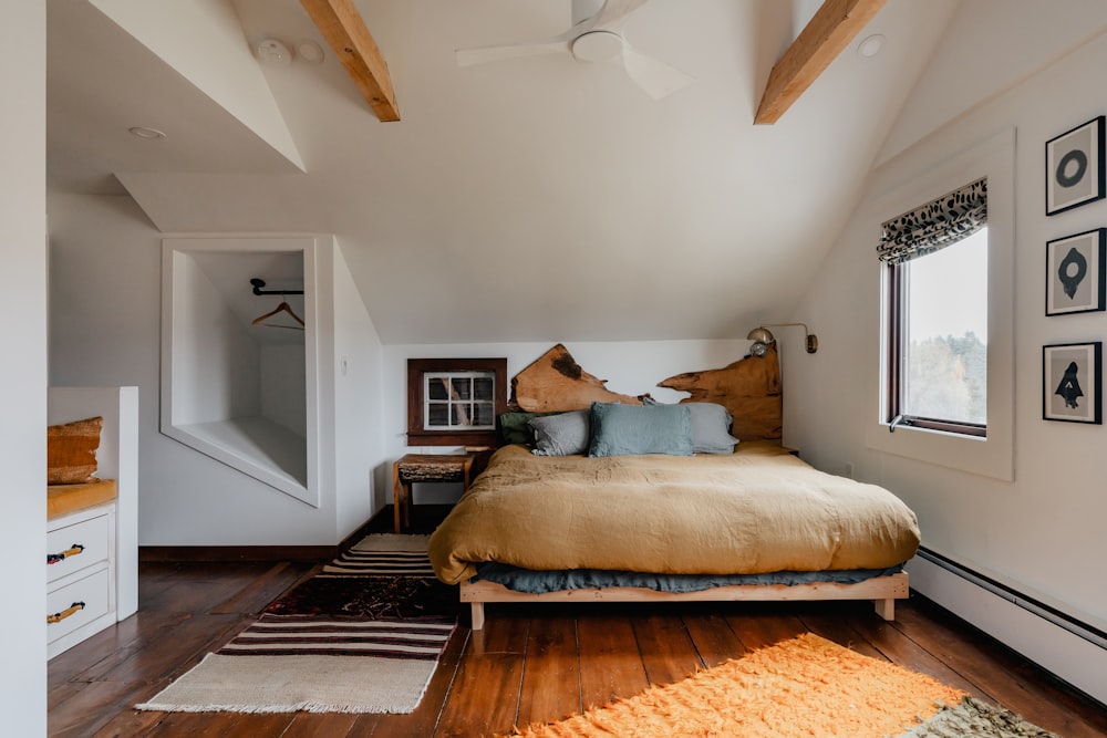 a bed sitting in a bedroom next to a window