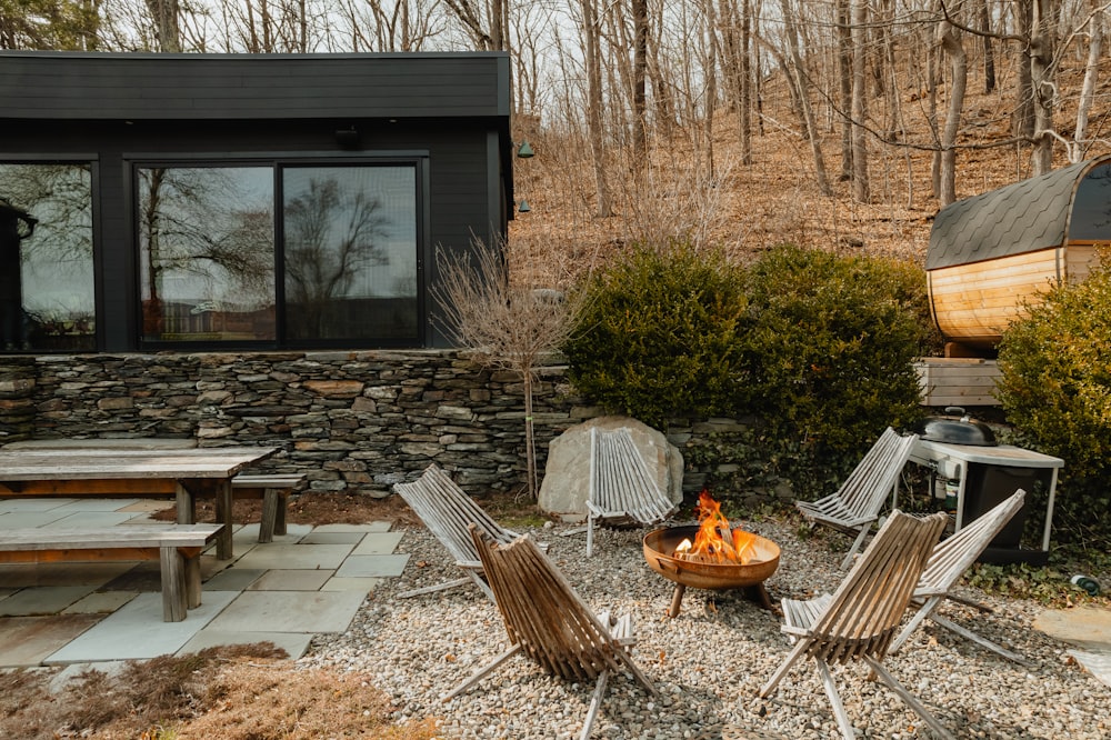 a fire pit surrounded by chairs and tables