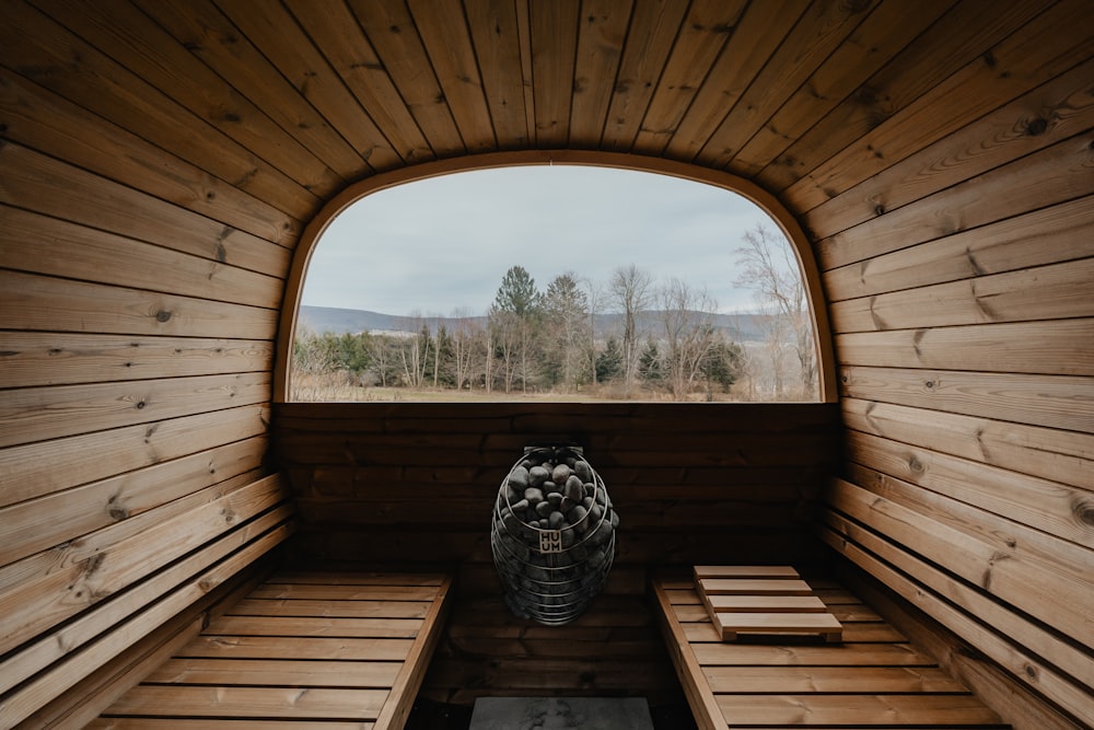 a wooden room with a large window and a bench