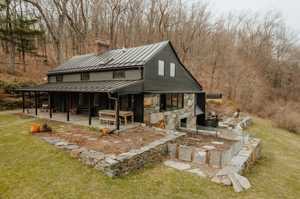 a house in the woods with a stone patio