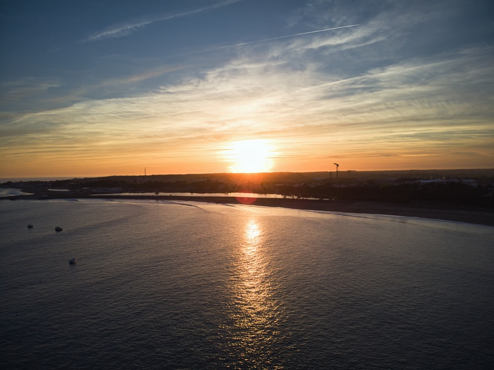 the sun is setting over a body of water