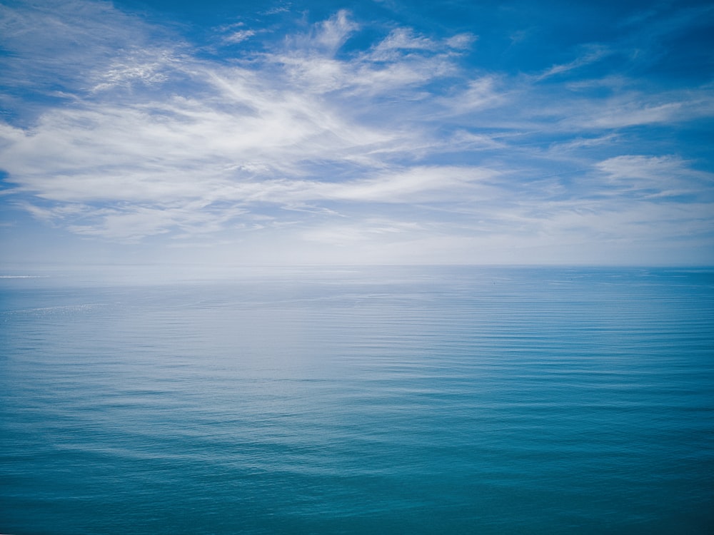 ein großes Gewässer unter einem wolkenverhangenen blauen Himmel