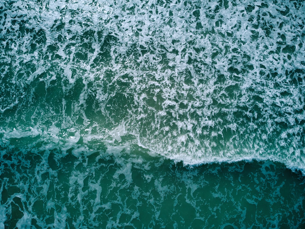 an aerial view of the ocean with waves