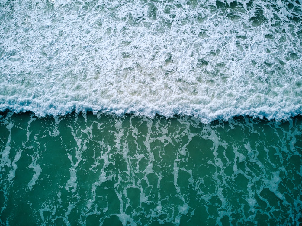 an aerial view of the ocean with waves