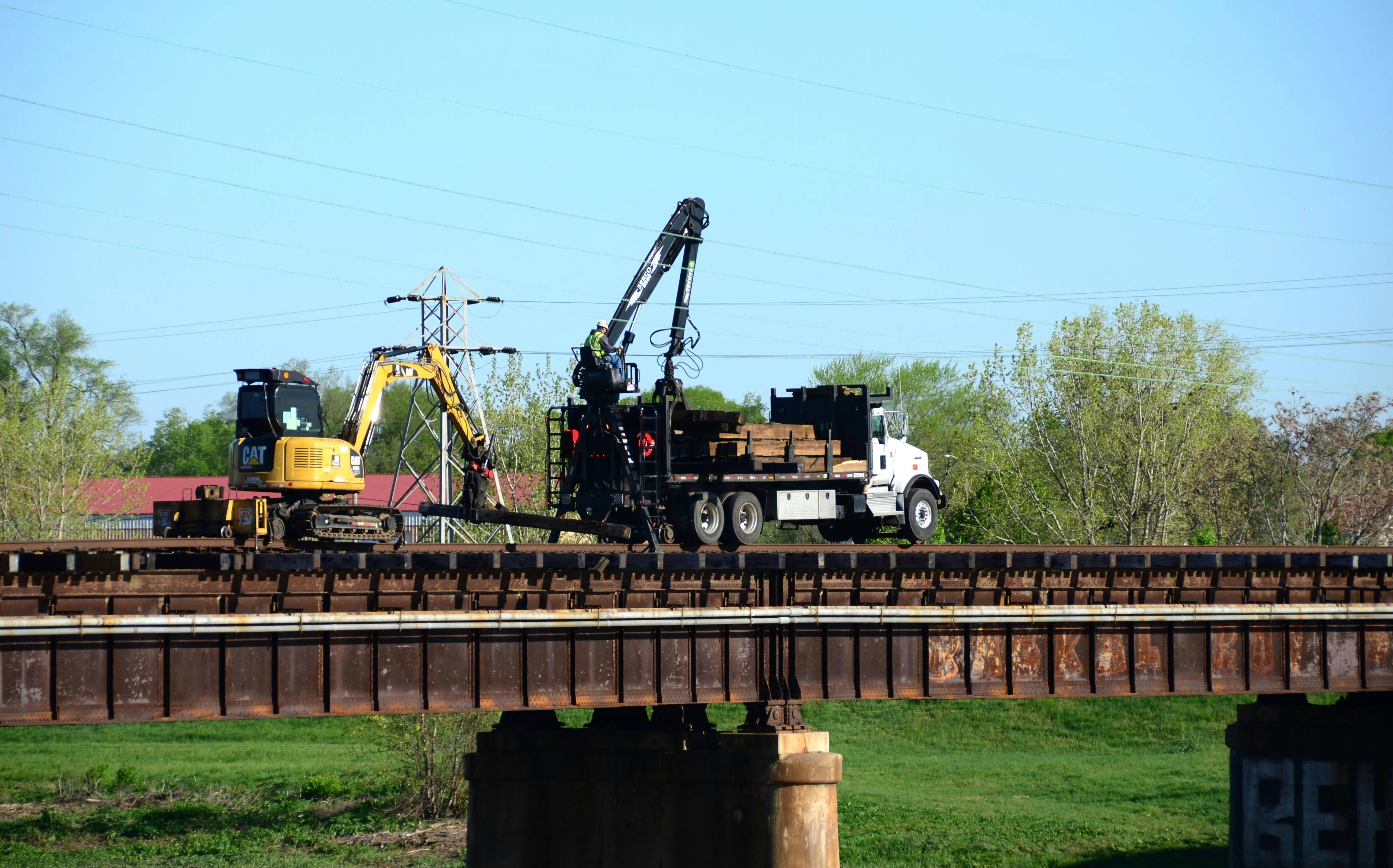 a crane is on top of a truck on a bridge