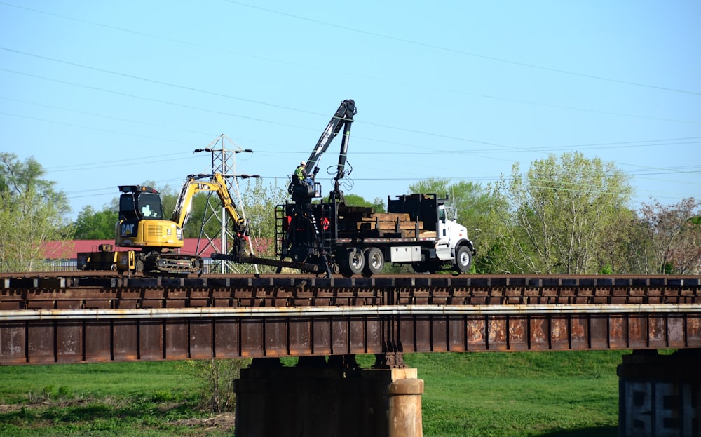 a crane is on top of a truck on a bridge