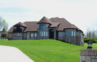 a large house sitting on top of a lush green field