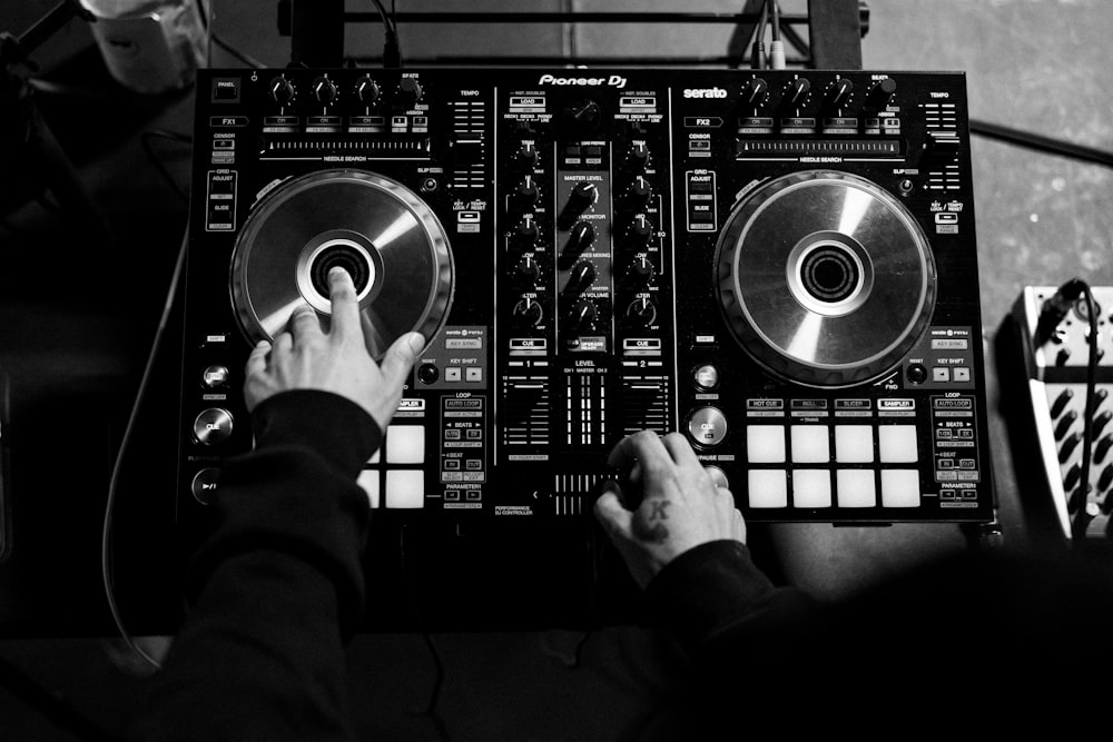 Una persona está tocando el tocadiscos de un DJ en un estudio de grabación