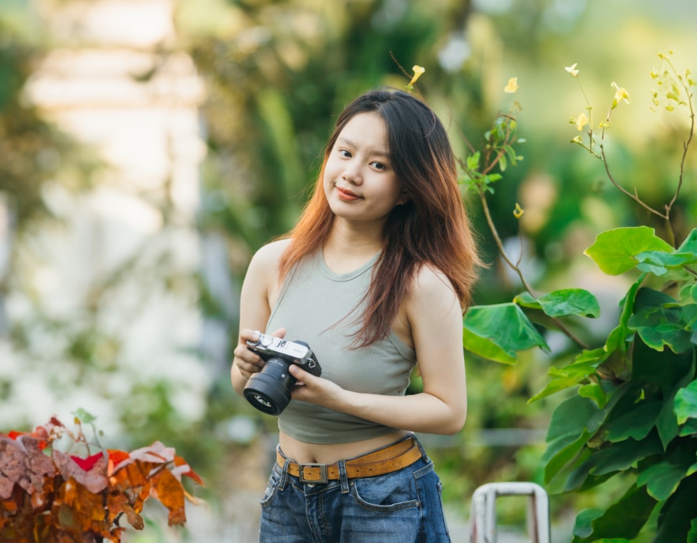 a woman holding a camera in a garden