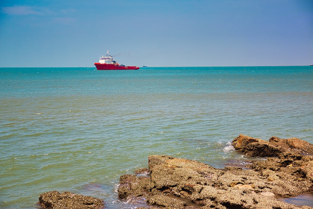 a large red boat in the middle of the ocean