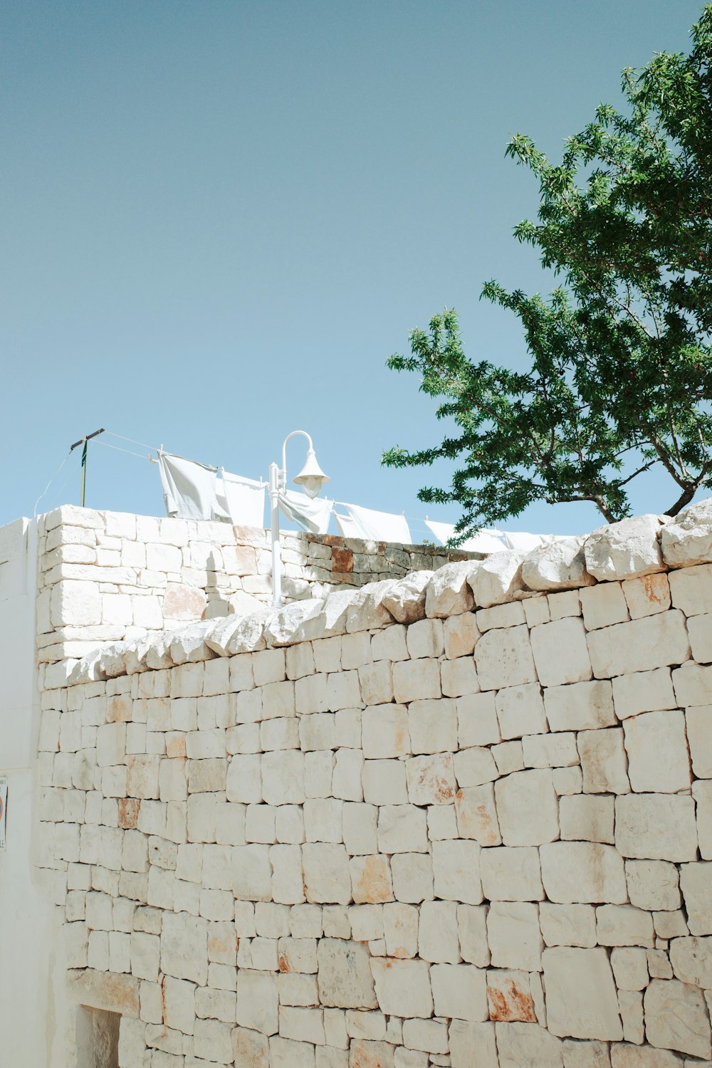 a stone wall with a white umbrella on top of it