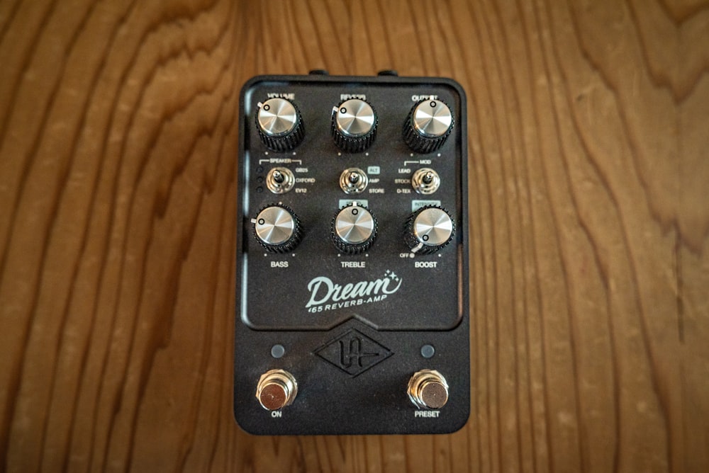 a close up of a guitar pedal over a wooden surface