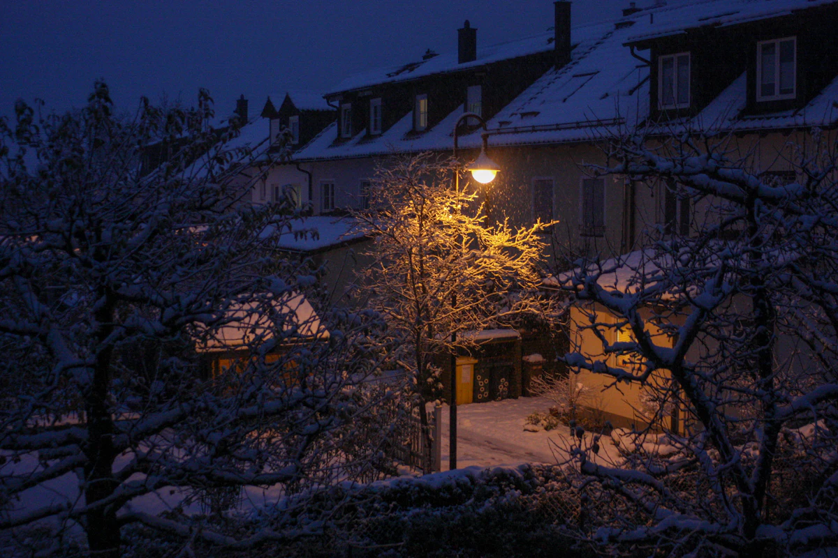 Een straatlantaarn in de sneeuw, in het blauwe uur