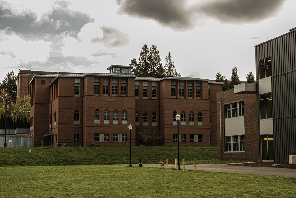 a large brick building sitting on top of a lush green field