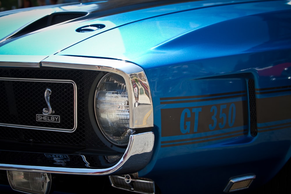 a close up of the front of a blue mustang