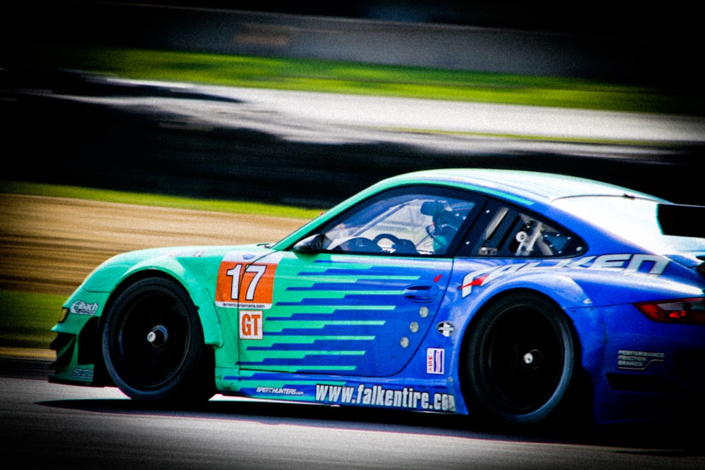 a blue car driving down a race track