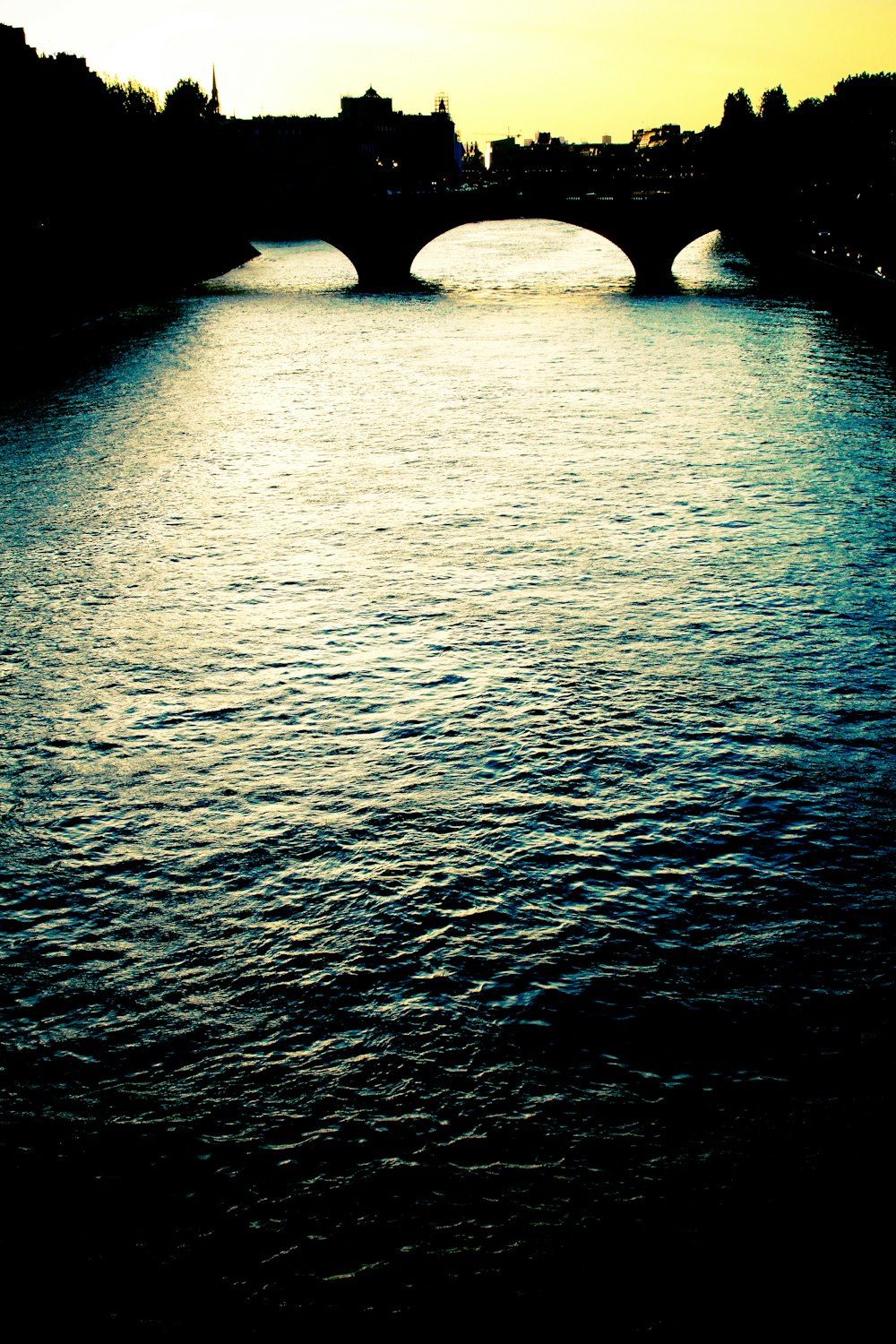 a bridge over a body of water with buildings in the background