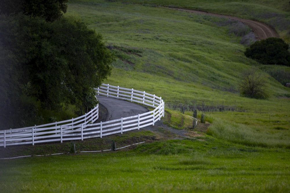 a white fence on the side of a road