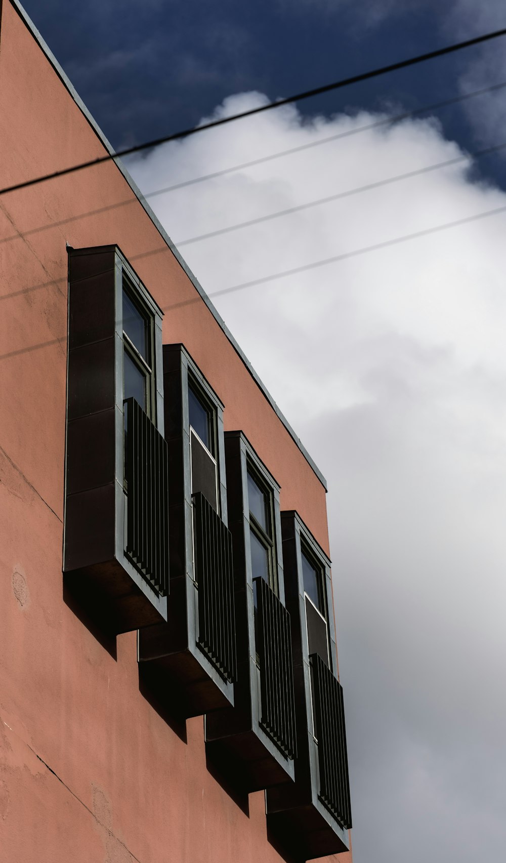 a red building with black shutters and a clock