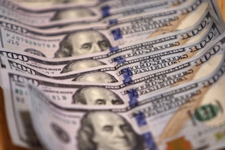 a stack of twenty dollar bills sitting on top of a wooden table