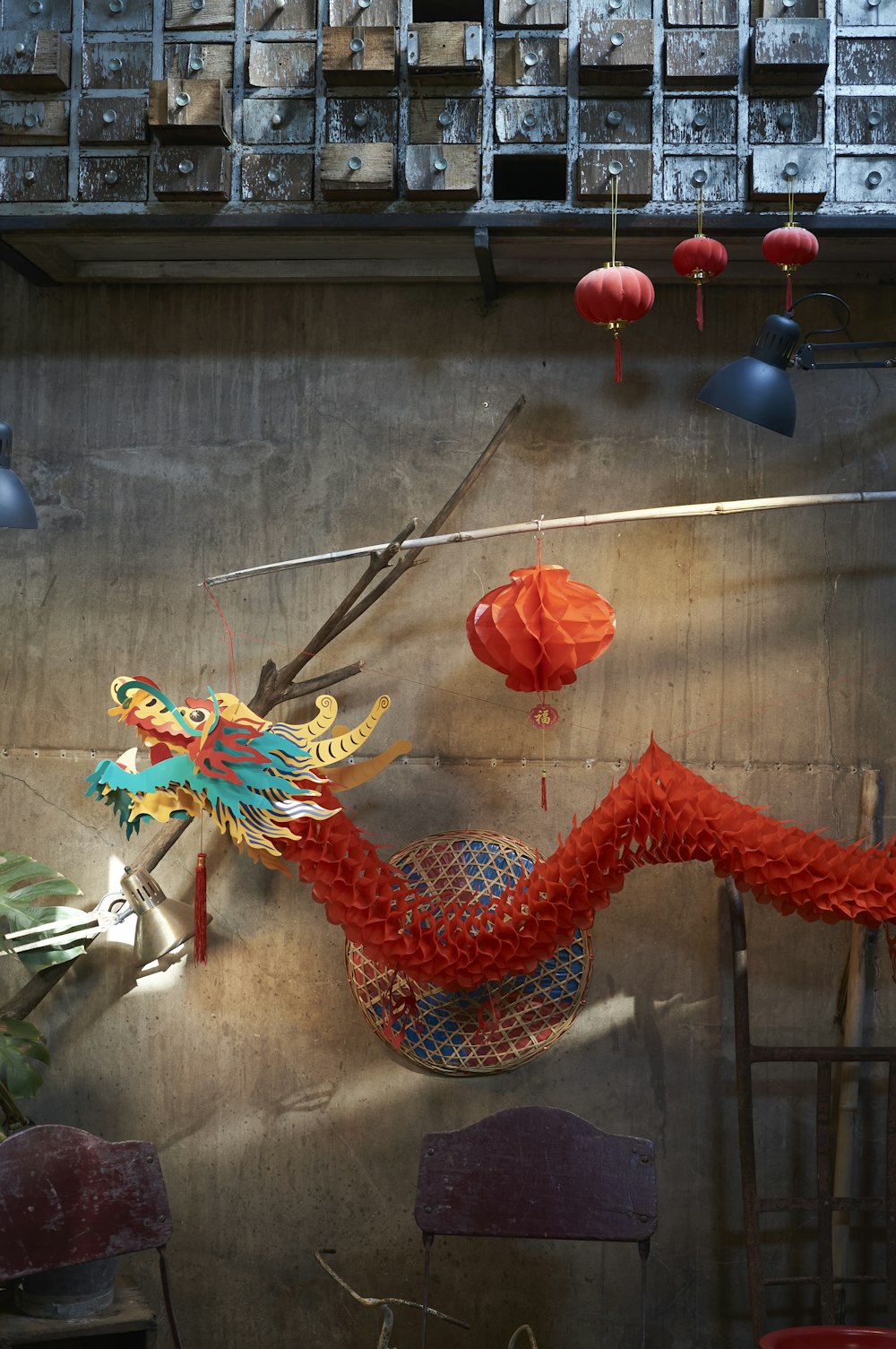 a red dragon sculpture hanging from a wall