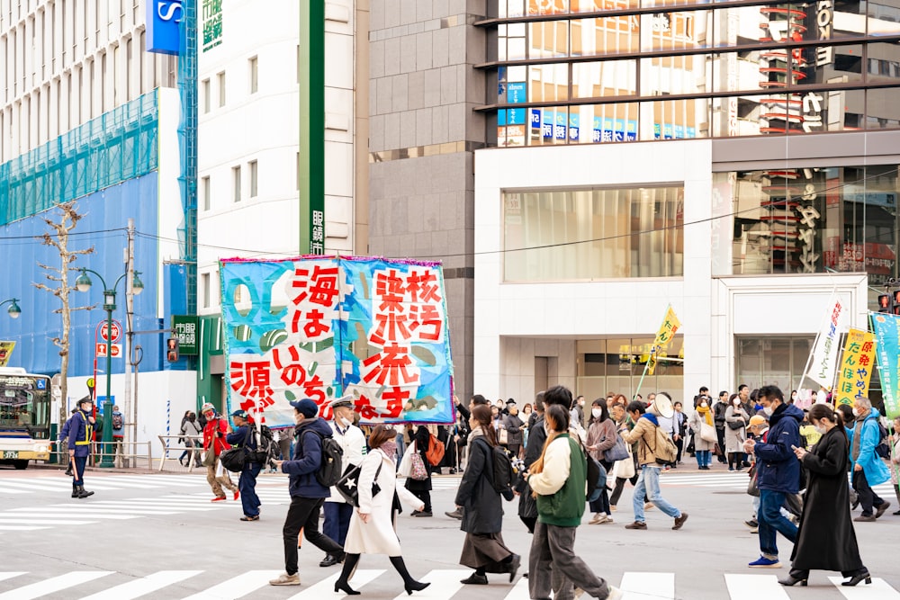 a group of people walking across a street