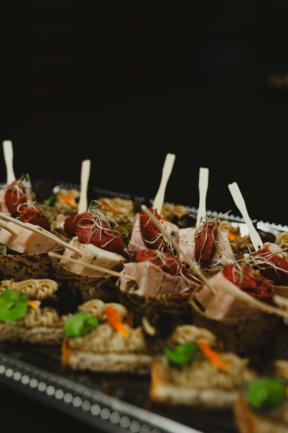 a tray of appetizers with toothpicks on them