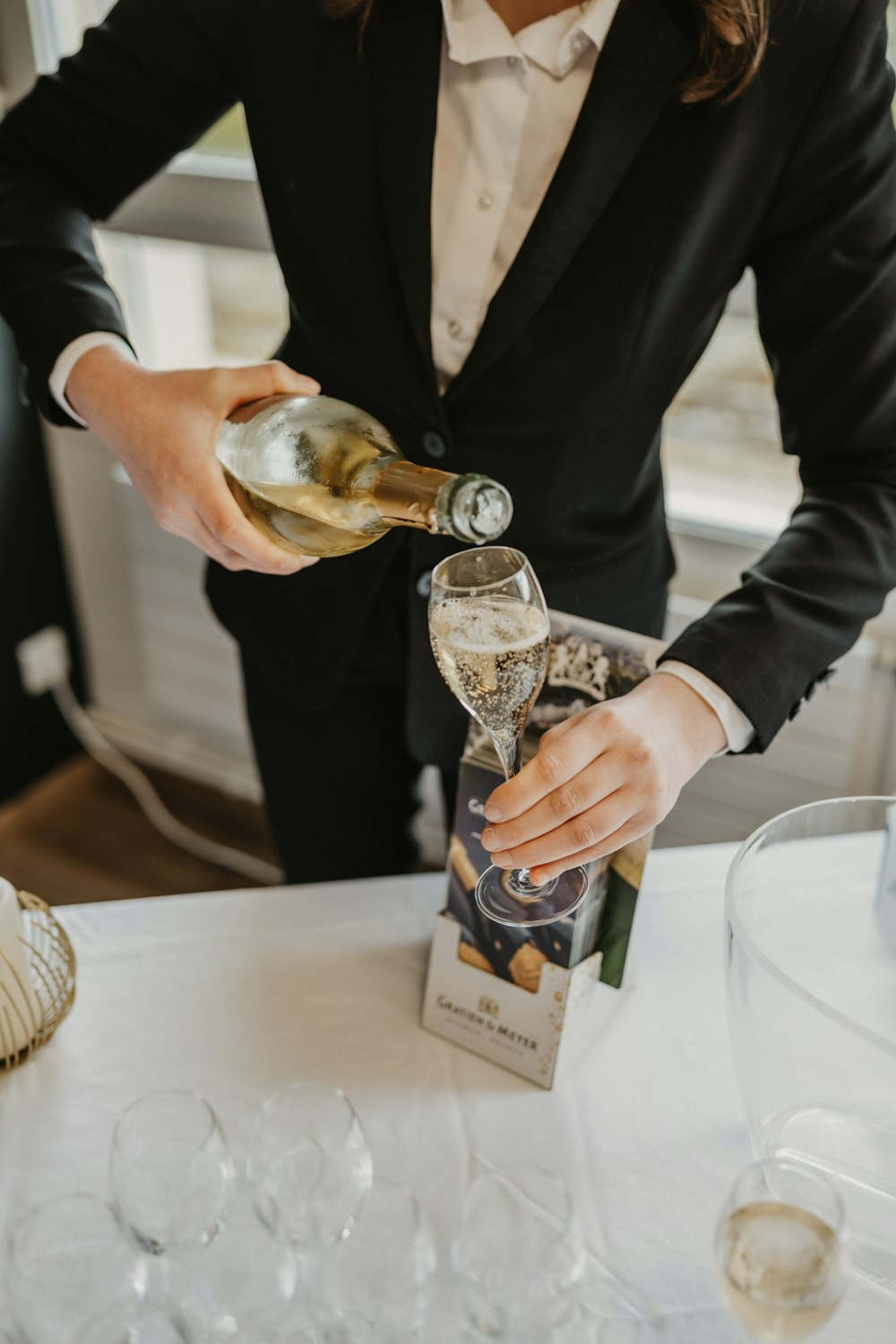 a woman pouring a glass of wine into a wine glass