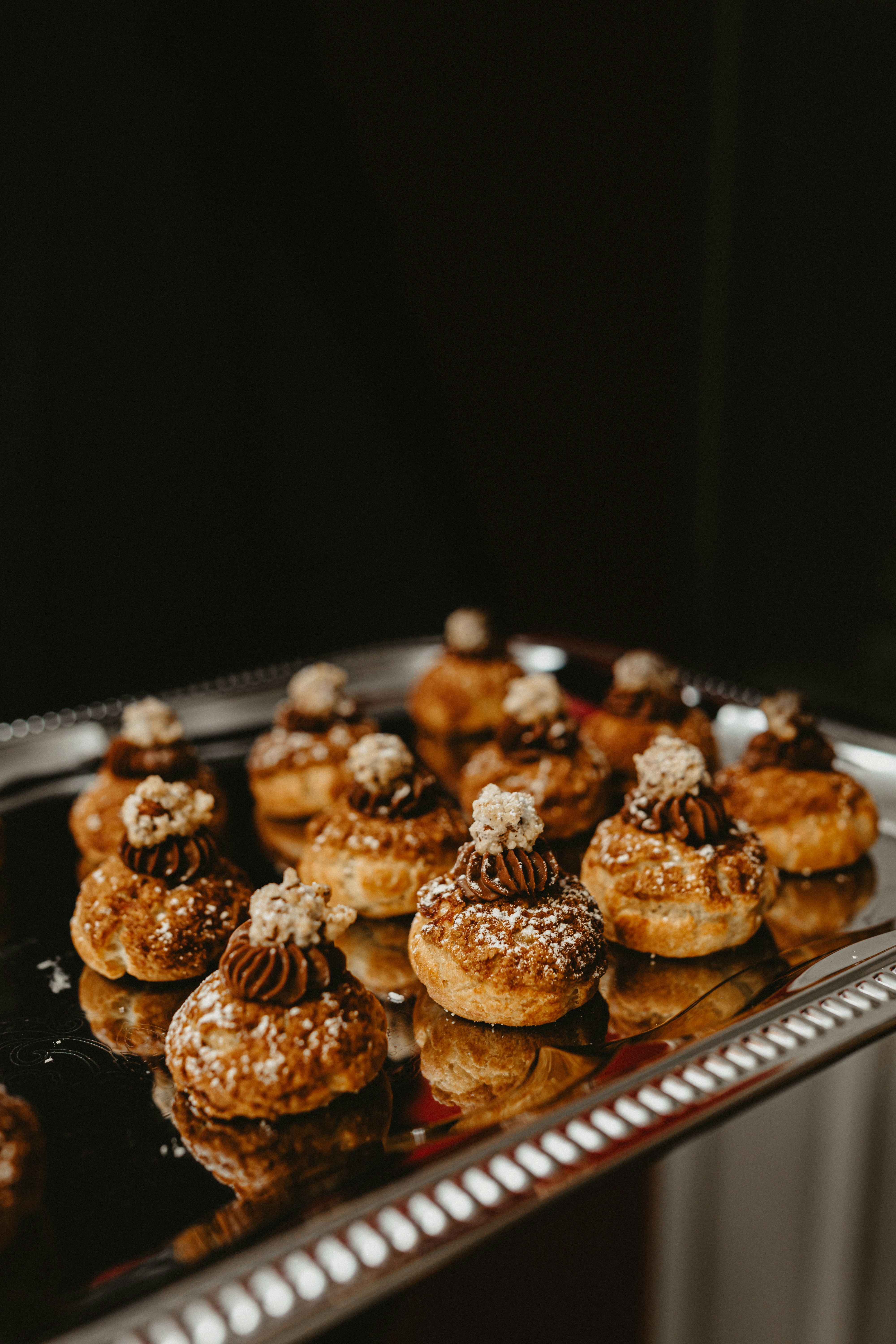a metal tray filled with pastries covered in powdered sugar