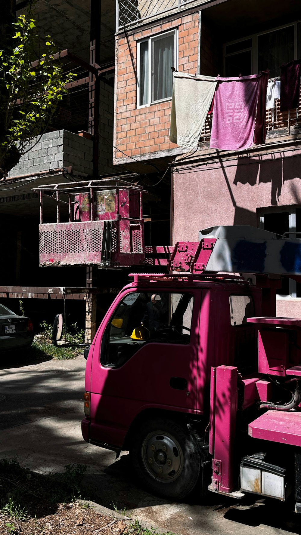 a pink truck parked in front of a building