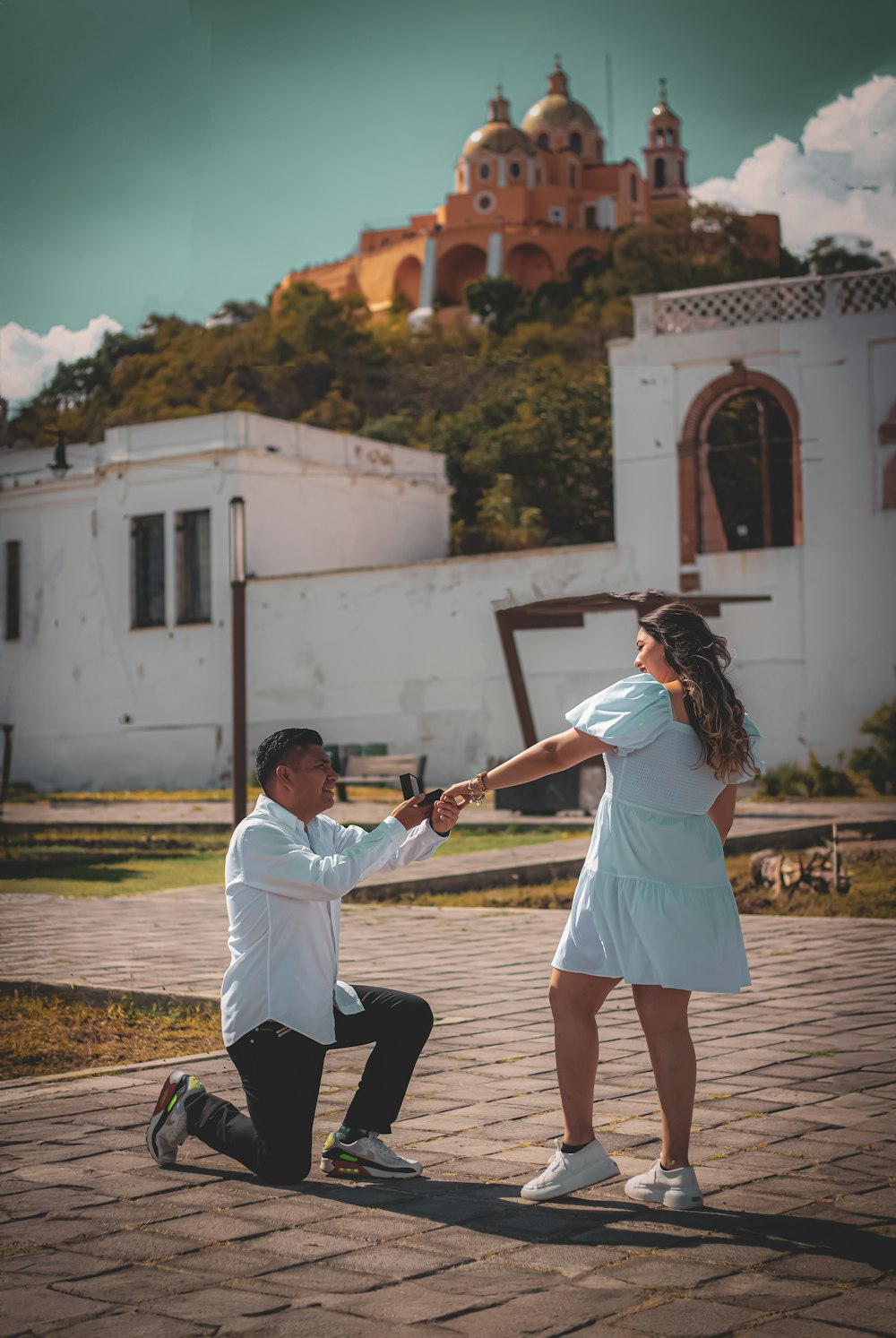 a man kneeling down next to a woman