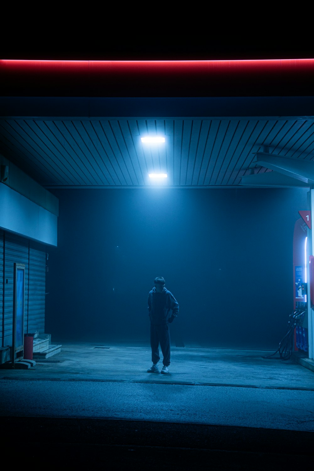 a man standing in a parking lot at night