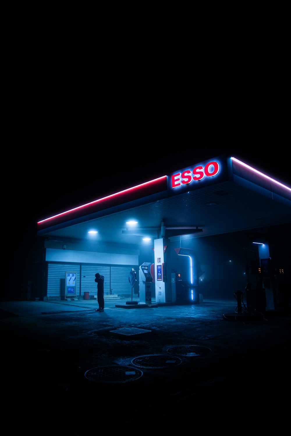 Una gasolinera iluminada por la noche con luces de neón