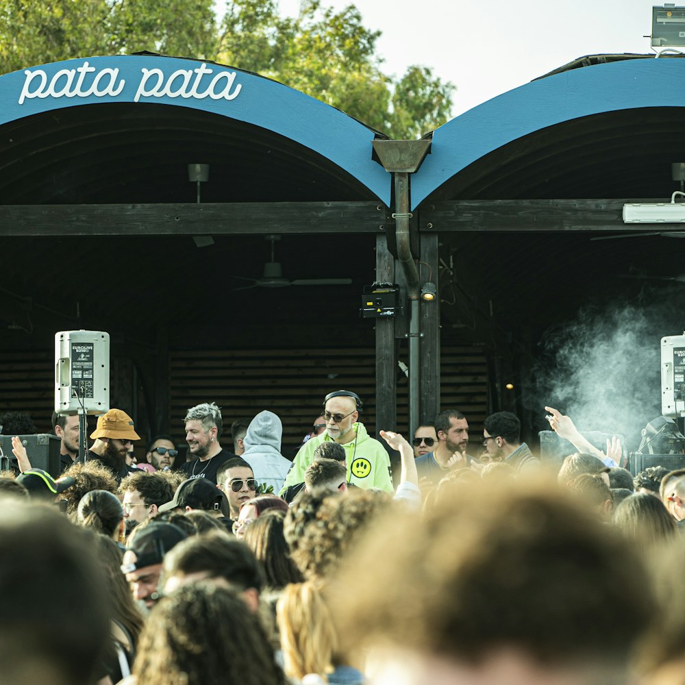 a crowd of people standing in front of a stage