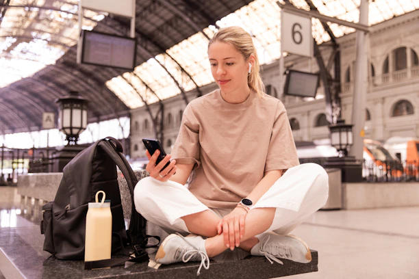 Woman using her phone to navigate transportation during her travels.