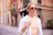 a woman in sunglasses is walking down the street