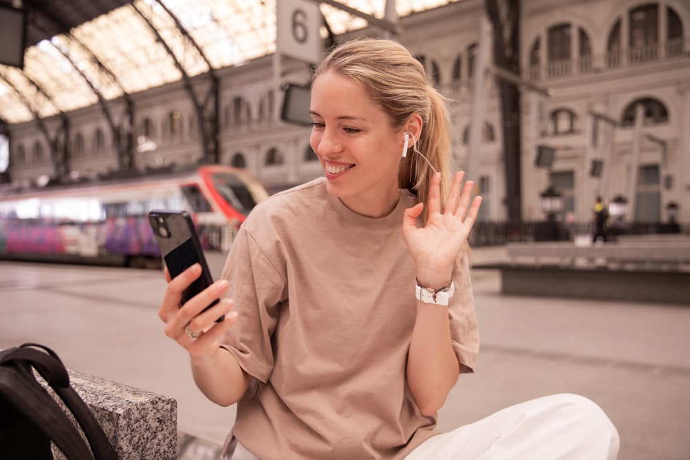 a woman sitting on a bench using a cell phone