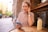 a woman sitting at a table using a cell phone