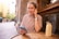 a woman sitting at a table using a cell phone