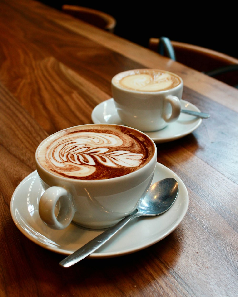 deux tasses de cappuccino sur une table en bois