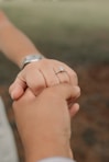 a close up of a person holding the hand of another person