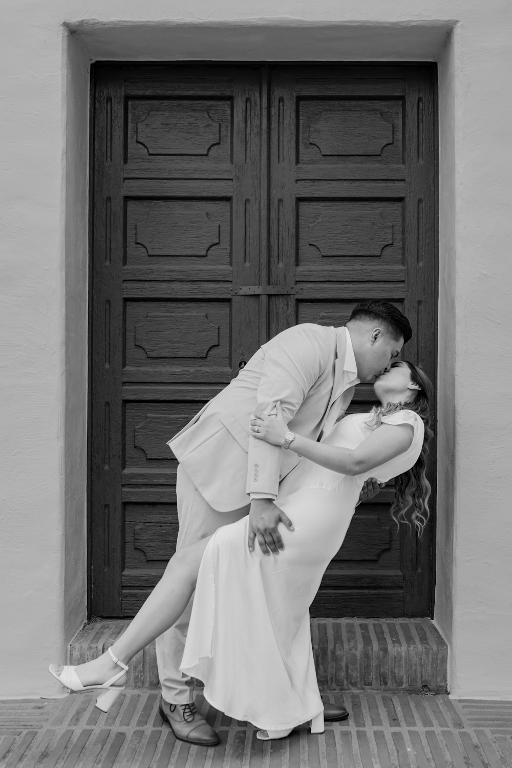 a man and woman kissing in front of a door