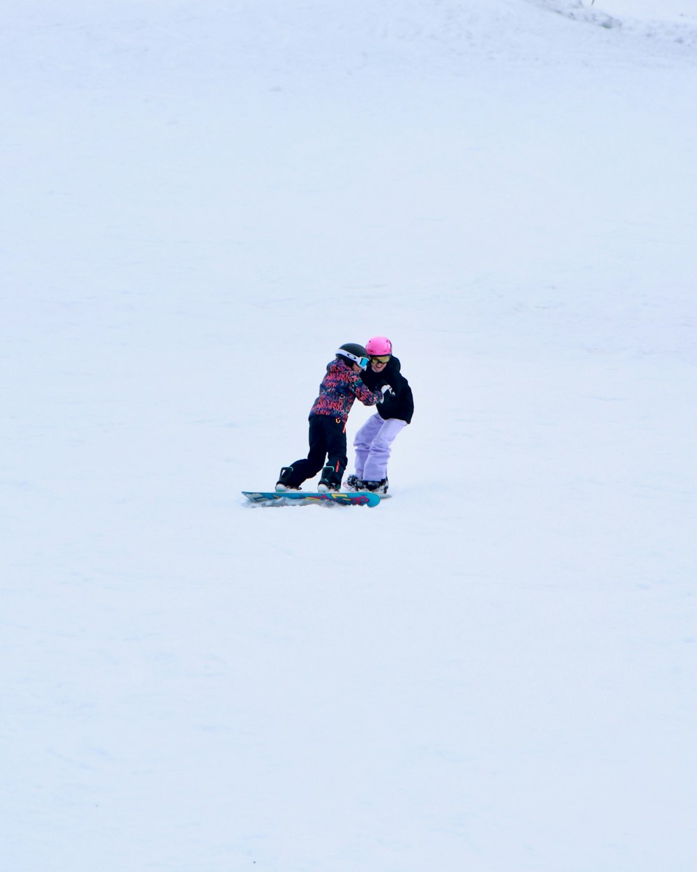 a man riding a snowboard down a snow covered slope