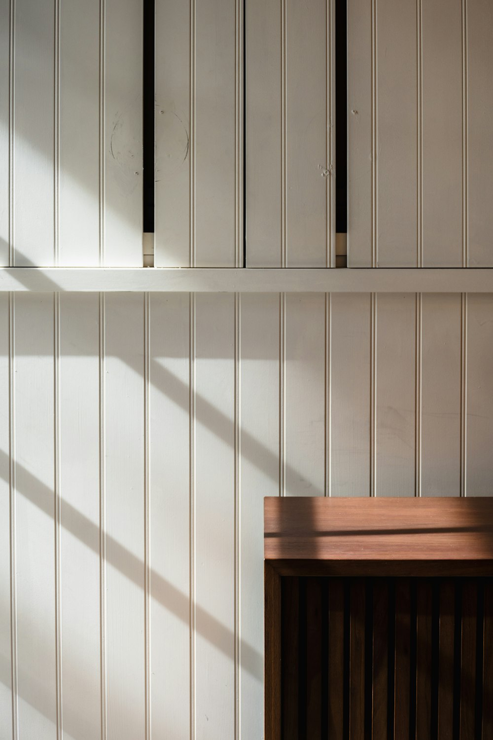 a room with a wooden table and white cupboards