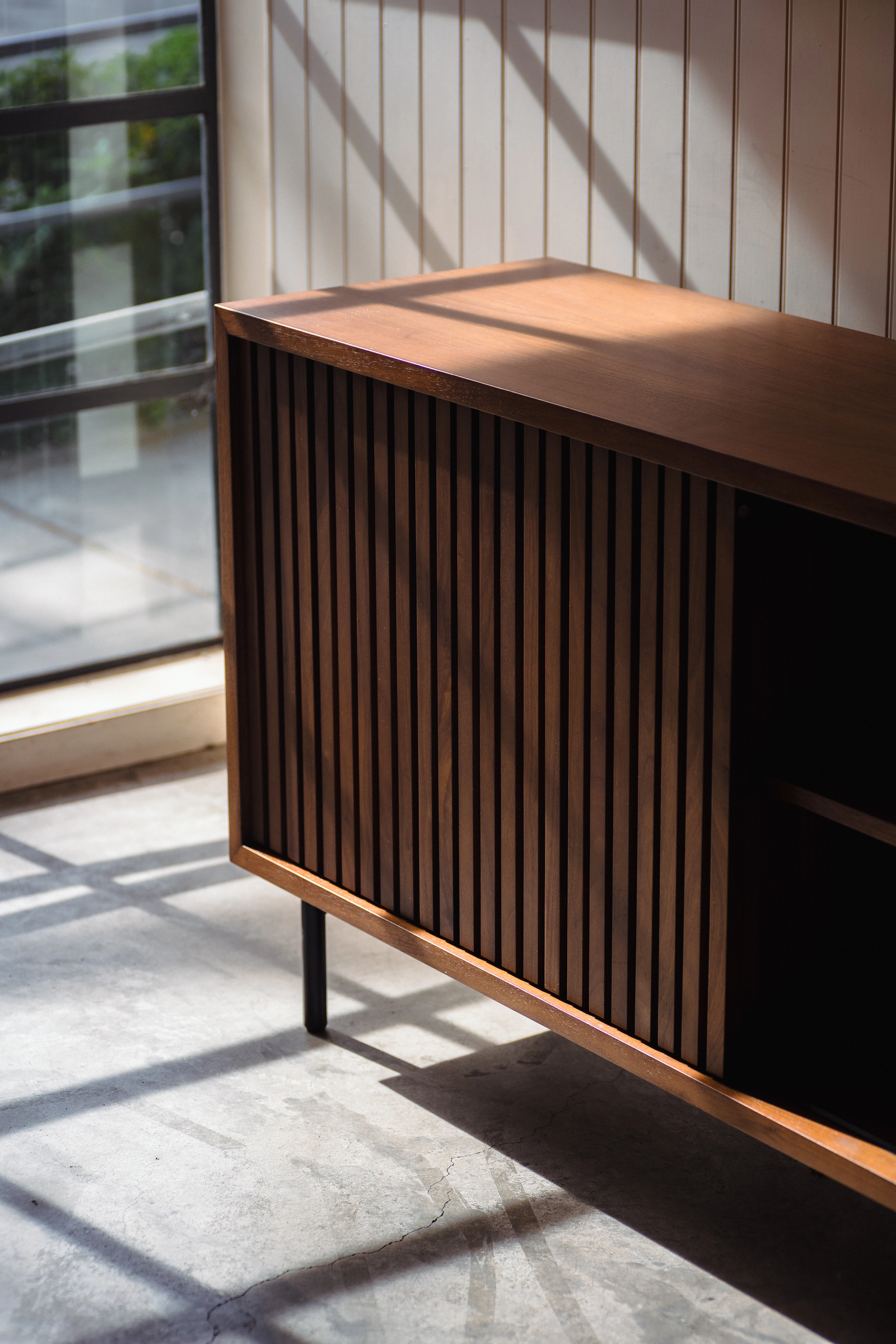 A wooden cabinet sitting in a room next to a window