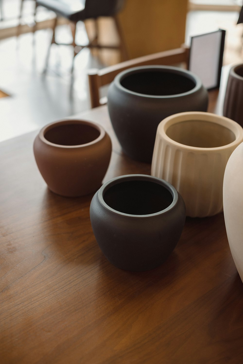 a group of vases sitting on top of a wooden table