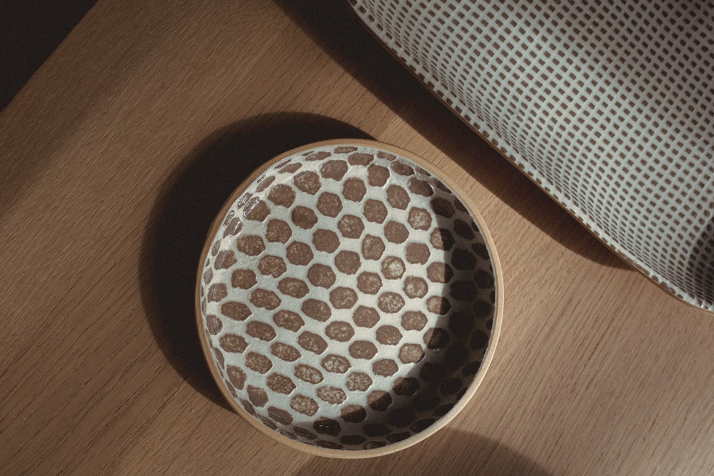 a brown and white bowl sitting on top of a wooden table