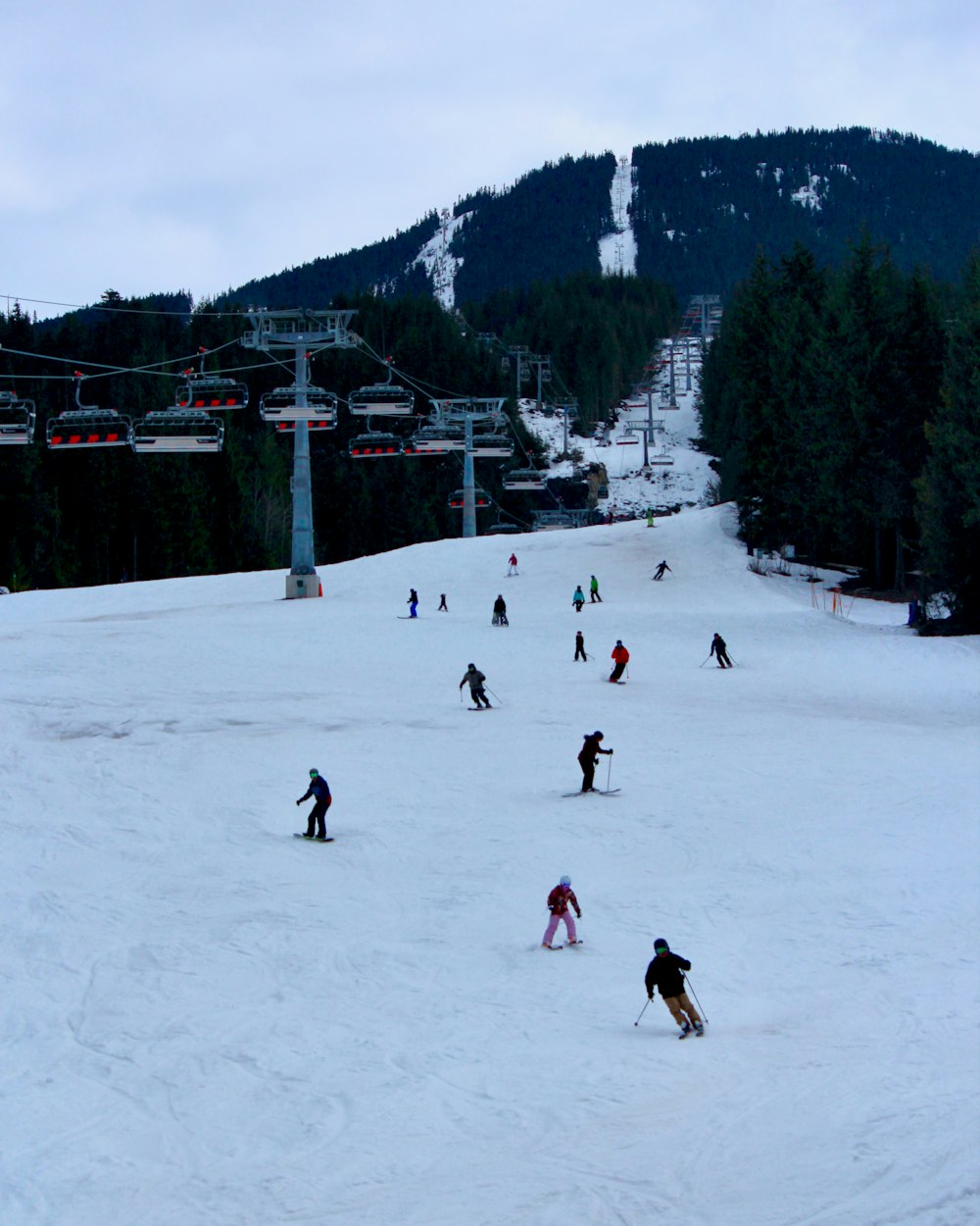 a group of people riding skis down a snow covered slope