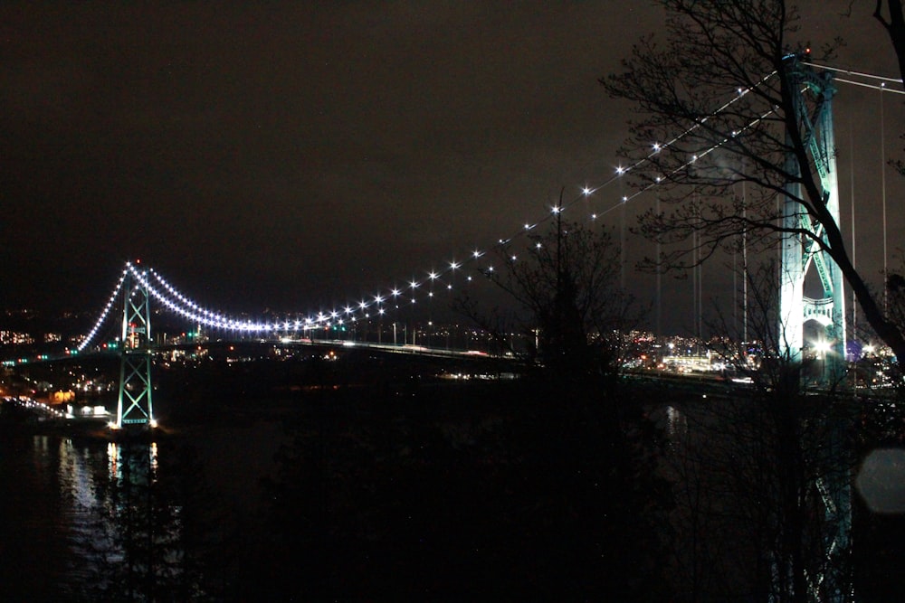 a night time view of a bridge over a body of water